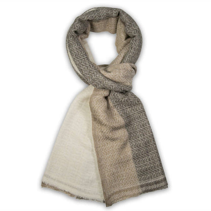 A double-sided scarf with a beige and brown herringbone pattern on one side and a solid cream/off-white color on the other, styled in a loop on a white background.