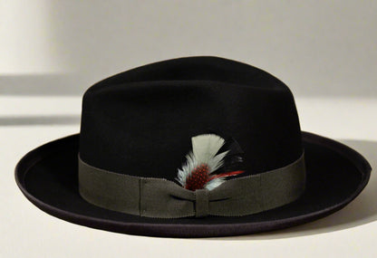 A black beaver fur felt hat with a charcoal grey grosgrain ribbon hatband and a feather accent.