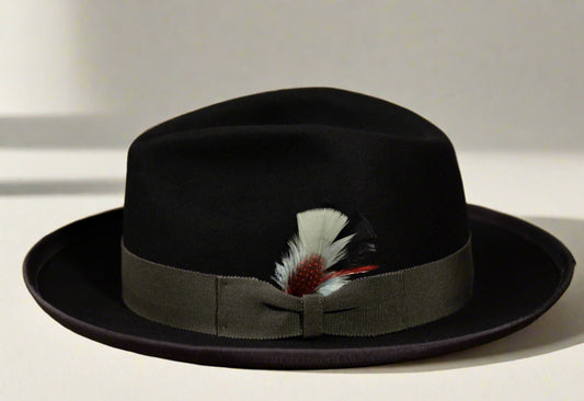 A black beaver fur felt hat with a charcoal grey grosgrain ribbon hatband and a feather accent.